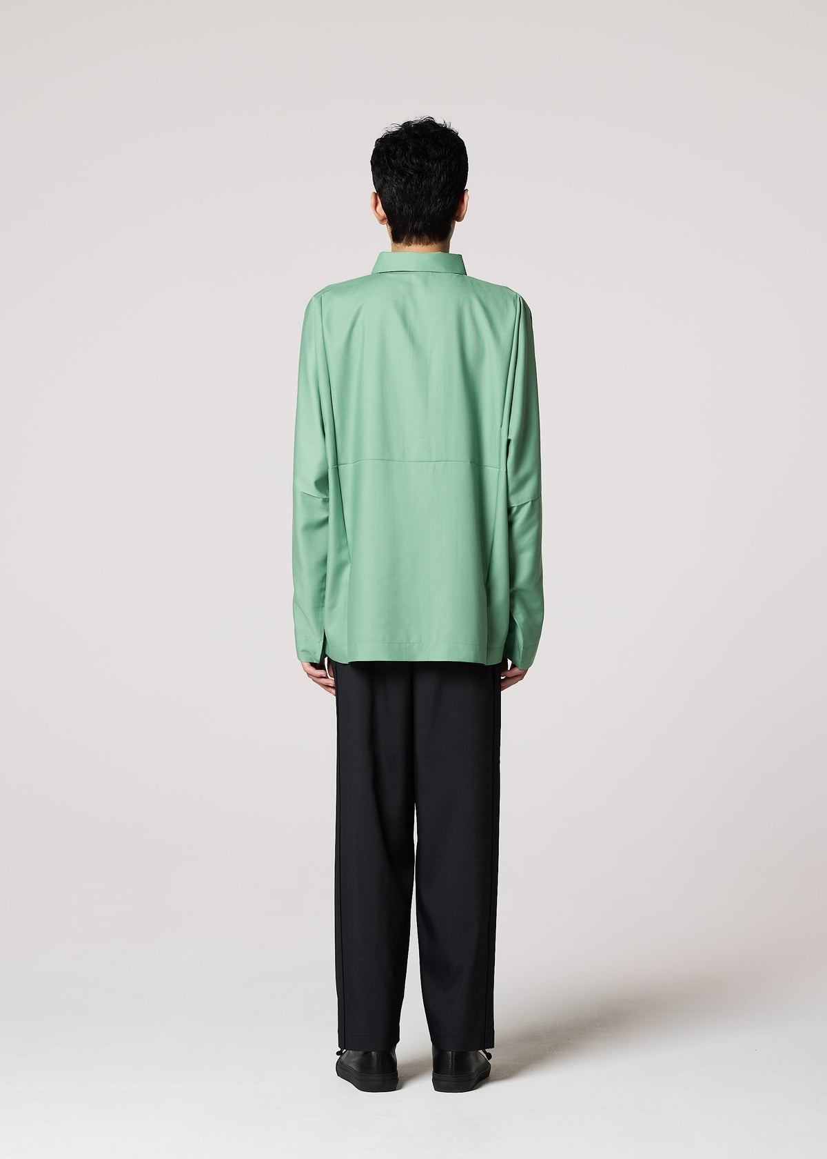 A person with short dark hair, seen from behind against a light gray background, wears the IM MEN COMPACT SHIRT in light green and loose black pants. view 11 of 12