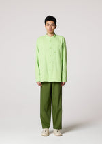 A person faces forward against a plain light background, wearing the IM MEN DOUBLE FACE COTTON SHIRT in light green, olive green pants, and white shoes. Their expression is neutral with arms at their sides.