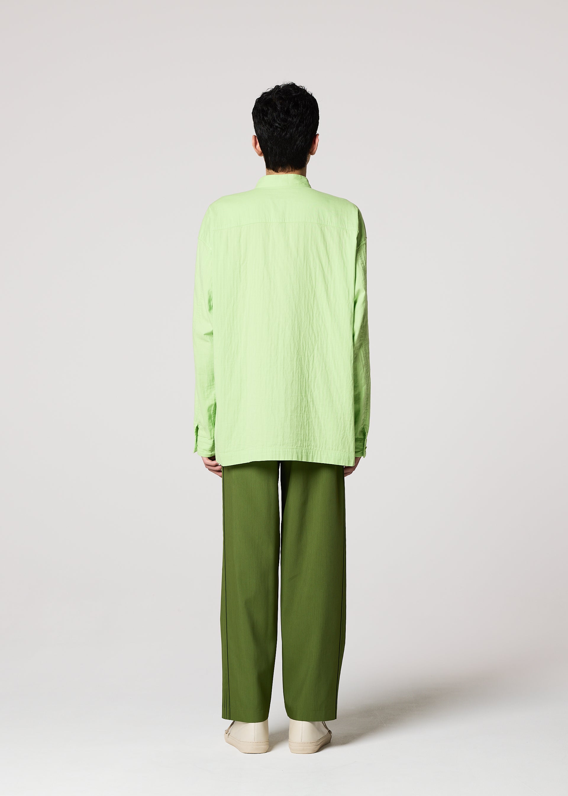 Zoomed view A person stands facing away from the camera wearing the IM MEN DOUBLE FACE COTTON SHIRT in light green, olive green pants, and beige shoes against a plain light background.