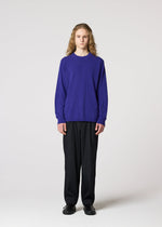 A person with long curly hair wears the IM MEN COMFORT loose, breathable, long-sleeved purple knit sweater made of cotton nylon yarn, paired with black pants and shoes, standing facing forward against a plain light background.