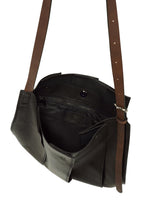 Introducing the LEATHER PLEATS by IM MEN—a black natural leather crossbody bag featuring brown adjustable straps. Shown open, it reveals an inner zippered pocket and multiple compartments, making it the perfect stylish 13-inch laptop bag for your daily essentials.