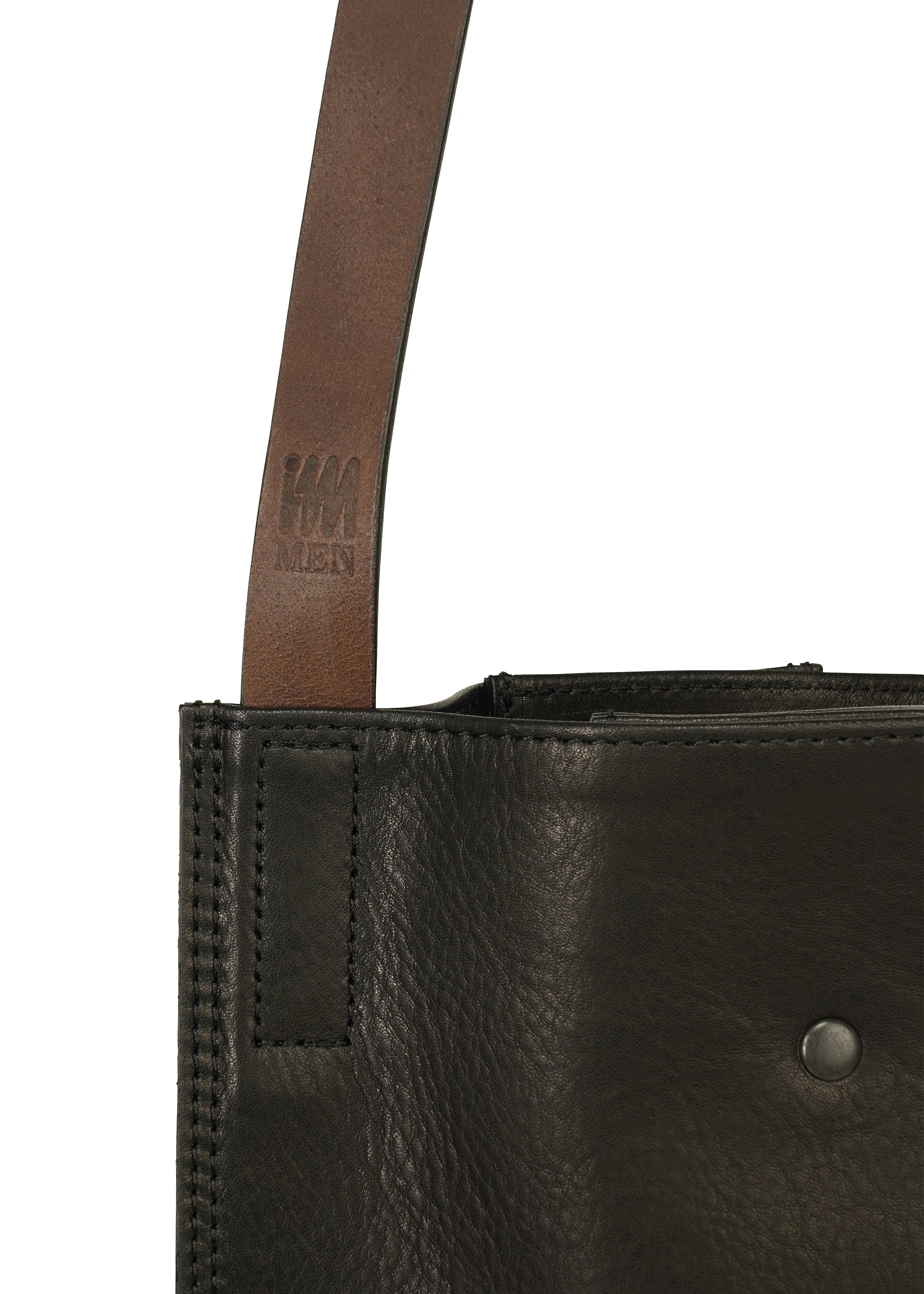 Zoomed view Close-up of the LEATHER PLEATS shoulder bag by IM MEN, made from black natural leather with visible stitching, featuring a dark brown leather strap and a small embossed IM MEN logo on the strap.