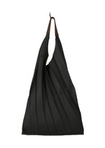 The GURU GURU tote bag by IM MEN is a pleated black fabric, foldable accessory with brown handles. Handmade pleats and diagonal folds give it a textured, sculptural look. Photographed against a white background. - BLACK （no.15）