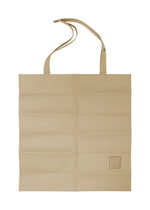 Beige polyester suede PATA PA tote by IM MEN with two handles, stitched squares, logo patch, and an extra strap with snap button on one handle, shown laid flat. - BEIGE （no.41）