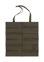 The IM MEN PATA PA is a flat, olive-green foldable tote bag with two handles, a long adjustable shoulder strap, and a small PATA PA patch at the bottom right. Made from polyester suede, shown against a white background. - DARK BROWN （no.45）