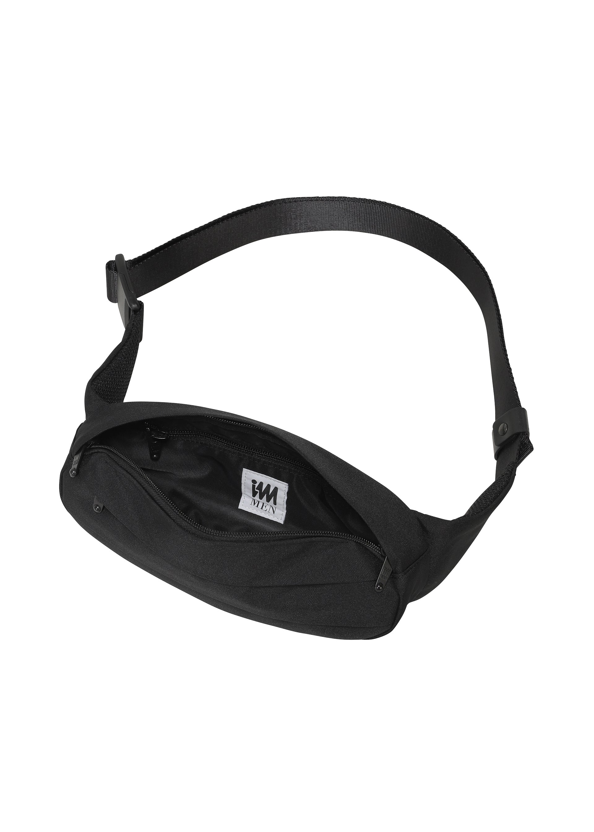 Zoomed view Introducing the CUMMERBUND BAG by IM MEN: This sleek black waist bag features an open zipper showcasing its spacious inner compartment and a white tag with black text. The adjustable strap ensures a comfortable fit, while its compact design is ideal for carrying your essentials. Subtle stitching inspired by a cummerbund motif adds an elegant touch to this sophisticated and practical accessory.