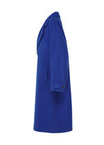 The FULLER WOOL by IM MEN is a knee-length, bright blue wool coat with a fluffy texture, notched collar, long sleeves with buttoned strap, and a single side pocket shown from the side.
