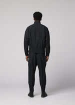 A person faces away from the camera, wearing the WAFT BLACK jacket and pants by IM MEN—both with gathered details and linen-like texture—paired with black shoes against a plain light gray background.