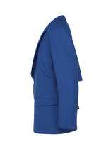 A blue SHRINK WOOL jacket by IM MEN is shown from the side on a plain white background, featuring long sleeves, lapels, and a slightly open front that reveals its tailored shape.
