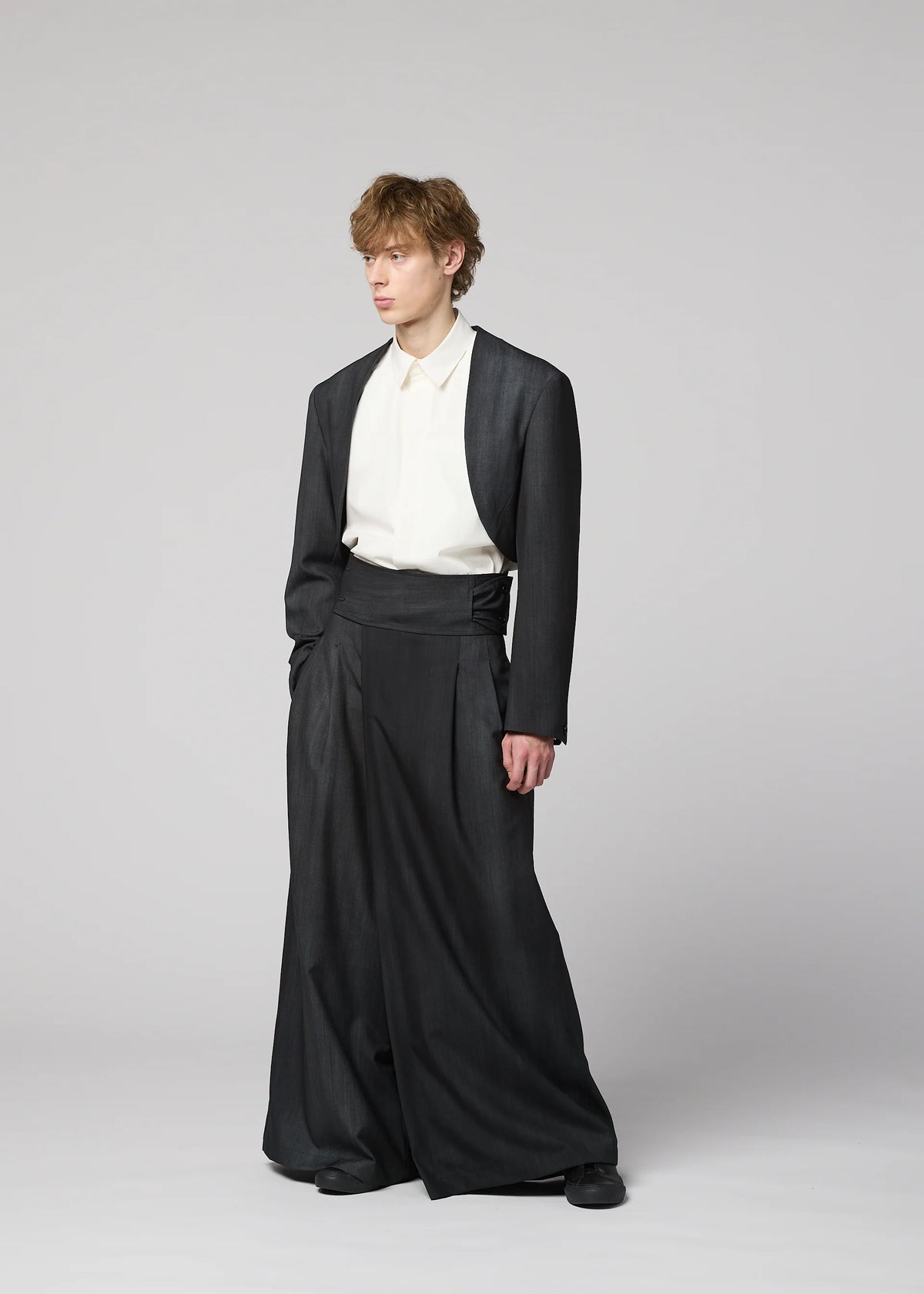 Zoomed view A person in wide-leg, high-waisted dark pants, a white collared shirt, and an IM MEN GRADATION WOOL jacket stands against a light grey background.