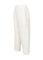 The CLAY pants by IM MEN are white, loose-fitting trousers made from sculptural fabric, featuring an elastic waistband, straight legs, and a button closure. They are shown on a white background at a slight side angle.