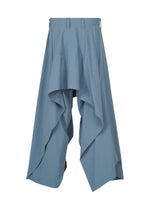 COMFORT COTTON by IM MEN features blue wide-leg pants in a high-twist organic cotton, showcasing a draped, layered silhouette with a high waist. Their distinctive asymmetric design creates irregular-cut hems for a skirt-meets-pants look.