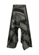 IM MEN’s KASURI pants are black and gray wide-leg culottes inspired by Kasuri weaving, featuring an abstract pattern, asymmetrical draped design, and belt loops. Shown on a white background. - BLACK （no.15）