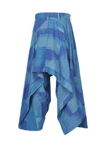 KASURI wide-leg pants or culottes by IM MEN, featuring a blue and teal pattern with an asymmetrical, draped design and pleats, displayed on a white background.