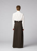A person stands facing away in a white shirt and IM MEN SHRINK WOOL wide hard-twist wool pants, set against a plain light gray background.