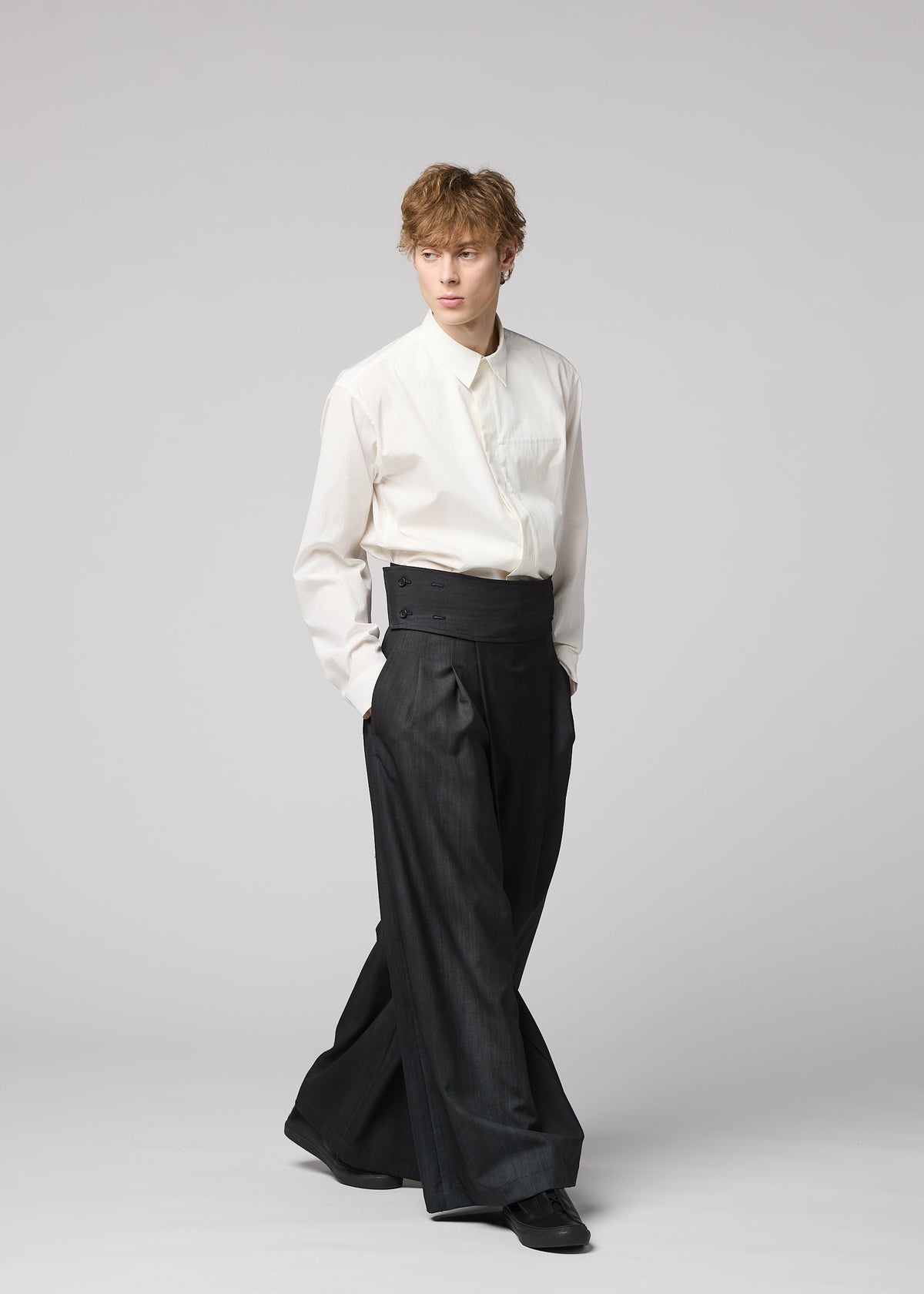 A person in a white dress shirt, tucked into IM MEN GRADATION WOOL pants with hands in pockets, stands against a plain light background. view 7 of 7