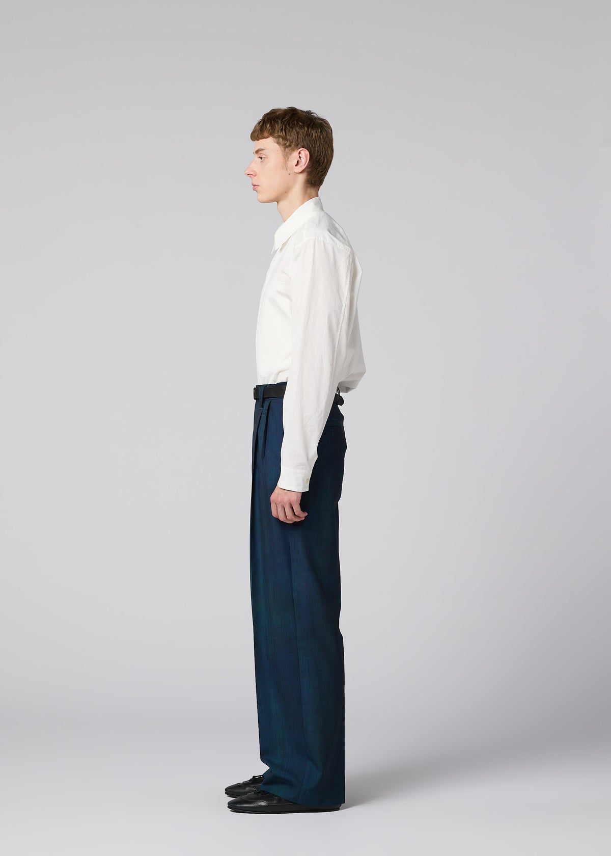 Zoomed view A young man stands in profile against a plain background, wearing a white long-sleeve shirt, IM MEN GRADATION WOOL pants, and black shoes.