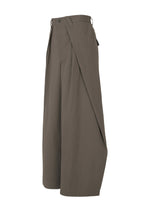 The OVERLAP trousers by IM MEN are wide-leg, high-waisted brown pants made from a textured cotton-nylon blend, featuring a distinctive wrap design and shown in profile against a white background.