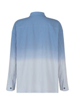 The DRIP SHIRT by IM MEN is a long-sleeved button-up crafted from cotton crepe, featuring a subtle textured finish and a striking blue-to-light-blue ombre gradient. Shown from the back, this shirt showcases the unique appeal of its gradient dye design.