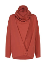The COTTON YAK shirt by IM MEN features a rust red hue, long sleeves, and a loose fit. Crafted from luxurious cotton yak fabric, it showcases a draped cowl neck and an asymmetrical front closure secured by a single button at the hem. Part of the IM MEN Autumn Winter 2026/27 collection.