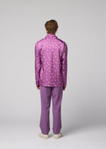 A person stands facing away, wearing the IM MEN MERRY SATIN SHIRT in purple with polka dots, paired with matching purple pants and white shoes, set against a plain gray background.