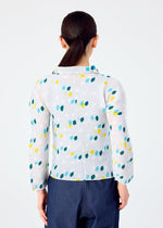 A person with long dark hair in a low ponytail is shown from behind, wearing the TIME DOTS white long-sleeved pleated top with blue, green, and yellow dot patterns by me ISSEY MIYAKE, paired with dark blue pants against a plain white background.