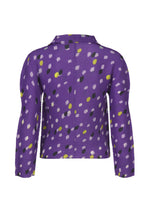The TIME DOTS top by me ISSEY MIYAKE is a long-sleeved, purple pleated blouse with a collar, featuring an abstract pattern of yellow, black, and light pink spots, shown from the back.
