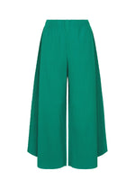 The SWING PLEATS pants by me ISSEY MIYAKE are high-waisted green knit pants with fine pleats and long draped side panels, shown against a white background. - PEACOCK GREEN （no.64）
