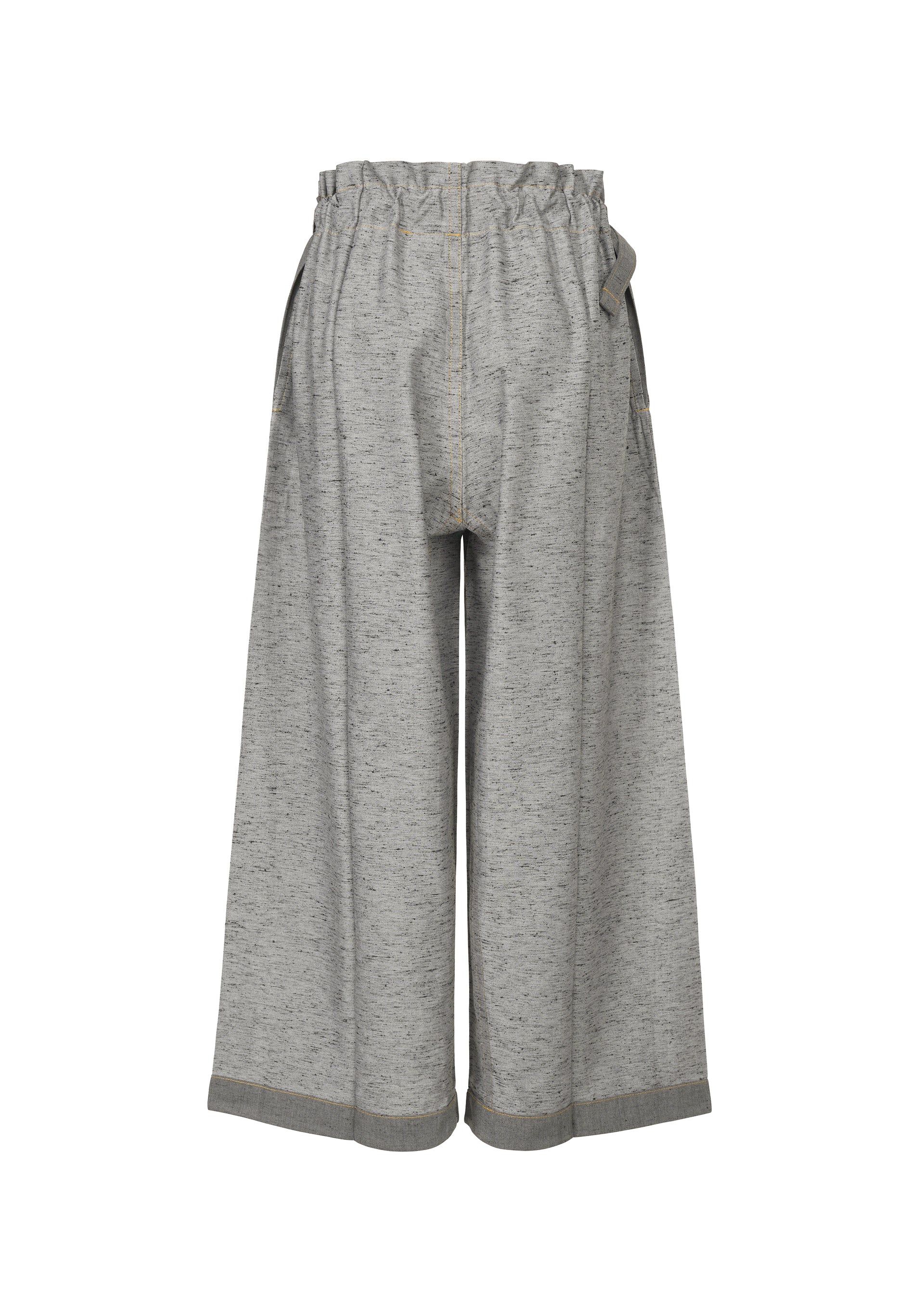 Zoomed view The me ISSEY MIYAKE REmeTEX NEP DENIM pants feature wide legs, an elastic ruffled waistband, visible seams, and a heathered look. Made from recycled polyester with a relaxed fit and subtly flared silhouette.
