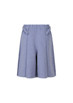 The FLAT BOTTOM shorts by me ISSEY MIYAKE are light blue, high-waisted with pleats, an elastic waistband, and decorative side tabs. They feature a loose fit and melange-like look, shown against a white background.