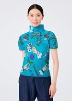 A smiling woman with straight black hair tied back wears the MAGIC top by me ISSEY MIYAKE, a bright blue high-neck short-sleeved shirt with cartoon hands performing magic tricks and holding playing cards, standing against a plain white background.