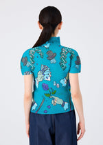 A person with long dark hair in a low ponytail is shown from behind, wearing the MAGIC top by me ISSEY MIYAKE— a blue high-neck short-sleeved shirt with playful prints—paired with dark pants.