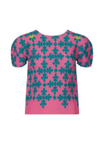 The SUIT by me ISSEY MIYAKE is a pink, short-sleeved stretch pleats top with green floral patterns in a diamond grid, inspired by playing cards. It features slightly puffed sleeves and a round neckline. - PINK-HUED （no.28）
