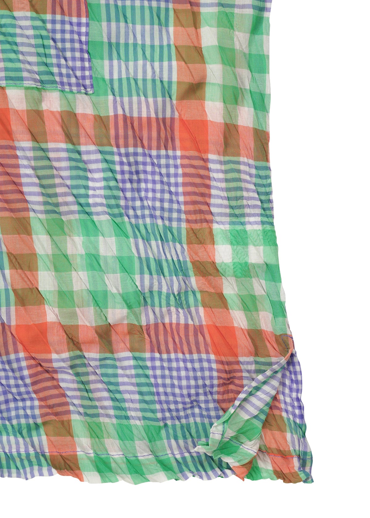 The CHECK WHIPPED PLEATS SHIRT by me ISSEY MIYAKE features lightweight, semi-sheer fabric with a multicolored yarn-dyed green, orange, blue, and white check pattern. The material is slightly wrinkled with a folded corner. view 4 of 7