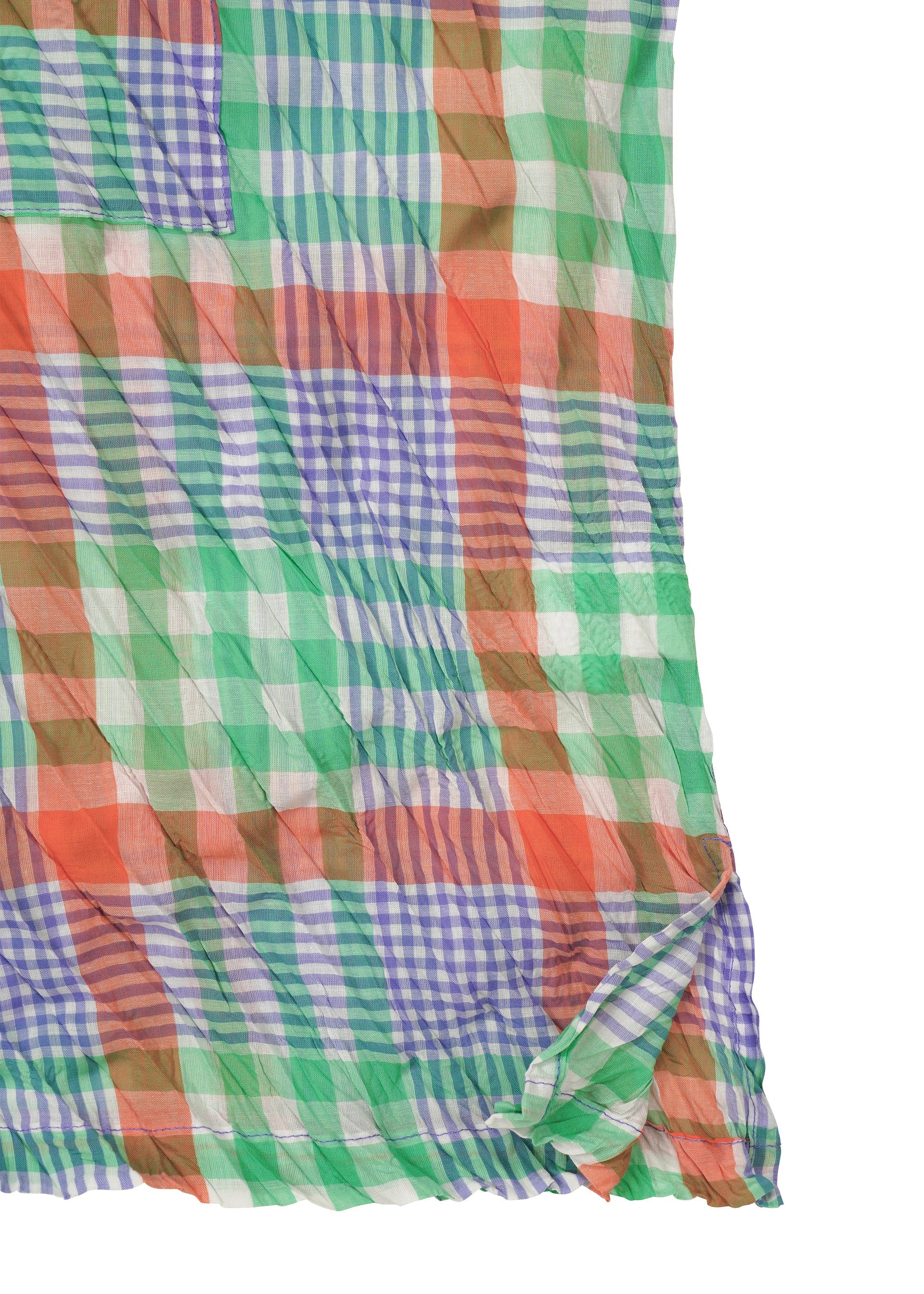 Zoomed view The CHECK WHIPPED PLEATS SHIRT by me ISSEY MIYAKE features lightweight, semi-sheer fabric with a multicolored yarn-dyed green, orange, blue, and white check pattern. The material is slightly wrinkled with a folded corner.