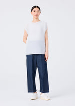 A person with dark hair pulled back and a neutral expression wears the SQUARE STRETCH PLEATS by me ISSEY MIYAKE—white round-neck top with French sleeves, loose blue pants, and white slip-on shoes against a white background.