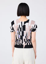 A person with short, straight black hair is seen from behind wearing the me ISSEY MIYAKE PERSPECTIVE patterned top in black, beige, and white with a round neck and short sleeves, paired with cream STRETCH PLEATS pants against a plain background.