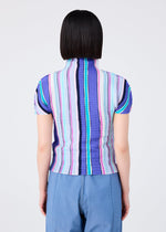 A person with straight, chin-length dark hair is seen from behind wearing the me ISSEY MIYAKE SHIRT STRIPE top—a high-neck, short-sleeved piece in vibrant blue, purple, pink, and white stripes—paired with light blue pants.