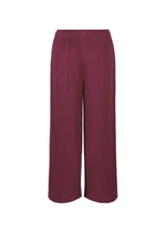 The WARM MESH PLEATS pants by me ISSEY MIYAKE feature a ribbed, textured fabric, wide-leg cut, high waist, pleated details, deep burgundy shade, and an elastic waistband.