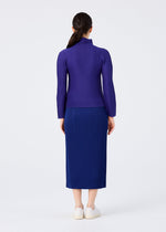 A woman faces away from the camera wearing the WARM MESH PLEATS blue midi skirt by me ISSEY MIYAKE, paired with a long-sleeved purple top and white slip-on shoes, against a plain white background.