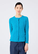 A person faces forward against a plain light background, wearing the CAULIFLOWER COLOR textured blue jacket and dark blue pants by me ISSEY MIYAKE.