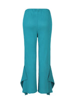 The FLAT SEE-THROUGH CREPE by me ISSEY MIYAKE features turquoise wide-leg pants in product-dyed fabric with an elastic waist and flared, asymmetrical ruffle hems, shown against a white background.