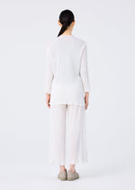 A person with long dark hair in a low ponytail faces away, wearing me ISSEY MIYAKE's SEE-THROUGH CREPE COLOR: a loose white long-sleeve top and matching see-through crepe pants, with light shoes, against a plain white background.