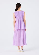 A woman with long dark hair in a ponytail stands with her back to the camera, wearing me ISSEY MIYAKE's SHIRT STRIPE CAULIFLOWER dress, sleeveless and pleated, paired with white slip-on shoes against a plain white background.