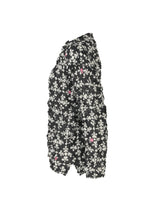 Side view of the SUIT MERINGUE TOP by me ISSEY MIYAKE—a textured black jacket with a white and pink floral pattern and a puffy, crushed pleat look—shown against a white background.