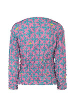 The SUIT MERINGUE TOP by me ISSEY MIYAKE is a long-sleeve shirt with a crushed pleat finish, featuring a colorful pink, teal, and yellow floral pattern and subtle playing card symbols on the textured back.