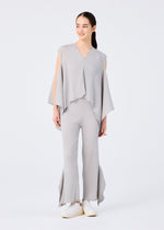 A woman wears the FLAT SEE-THROUGH CREPE set by me ISSEY MIYAKE: a light gray, sleeveless, loose top with uneven hems and matching wide-legged pants with frayed bottoms. She stands against a plain background with her long dark hair tied back and white shoes.