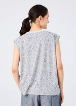 A person with dark hair in a ponytail is shown from behind, wearing the me ISSEY MIYAKE REmeTEX NEP JERSEY sleeveless top and gray pants, standing against a plain light background.