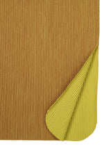 A close-up of the me ISSEY MIYAKE MIX FINE KNIT PLEATS BOTTOM, showcasing its lightweight, rectangular shape with ribbed pleats and a brown top layer. The folded corner reveals a yellow underside and textured detailing on both sides.