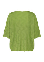 The me ISSEY MIYAKE WAVE KNIT STRETCH PLEATS is a light green, loose-fit knit top with short sleeves, pleated texture, and a wavy hem, shown in a relaxed silhouette against a white background.